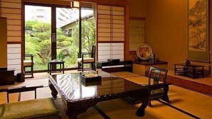 A traditional Japanese room with tatami flooring, a low table, and sliding doors. - Ryotei Takano (Chikuma)