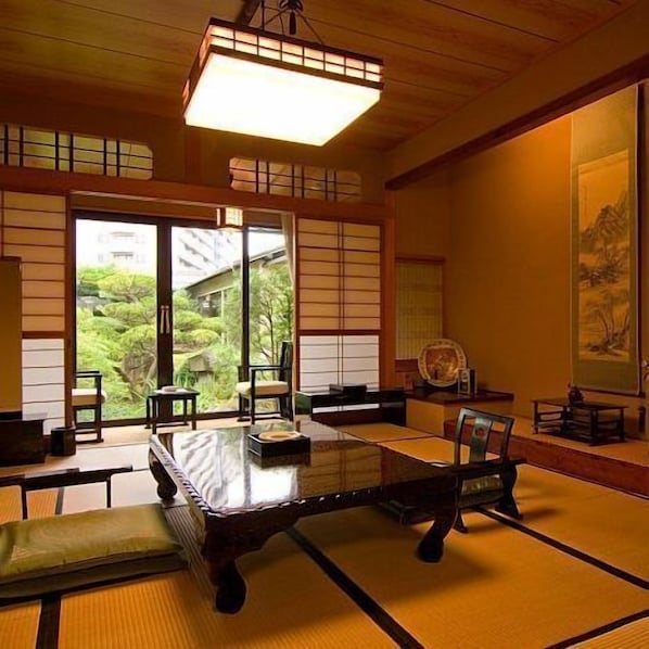 A traditional Japanese room with tatami flooring, a low table, and sliding doors.