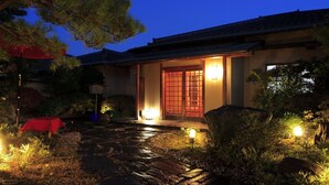 A traditional building with a tiled roof, a wooden door with glass panels, and a stone pathway leading to the entrance. - Ryotei Takano (Chikuma)