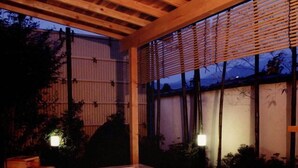 A wooden hot tub with a view of the sky and trees. - Ryotei Takano (Chikuma)