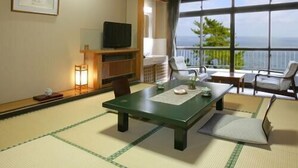 A traditional Japanese-style room with tatami flooring, a low table, and a view of the sea. - Itsuura Kanko Hotel Daikanso (Kitaibaraki)