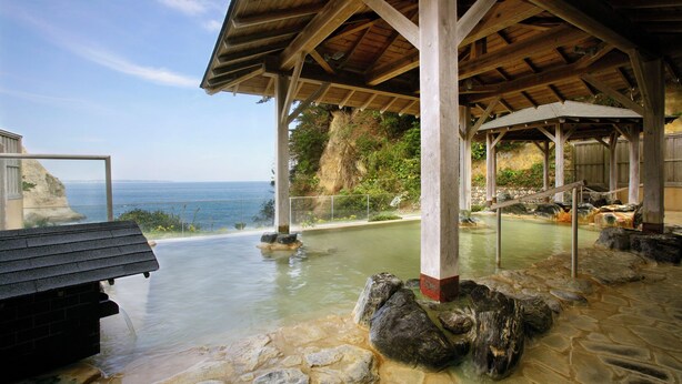 A stone pool with a wooden pavilion, a view of the ocean, and a rocky landscape. - Itsuura Kanko Hotel Daikanso (Kitaibaraki)