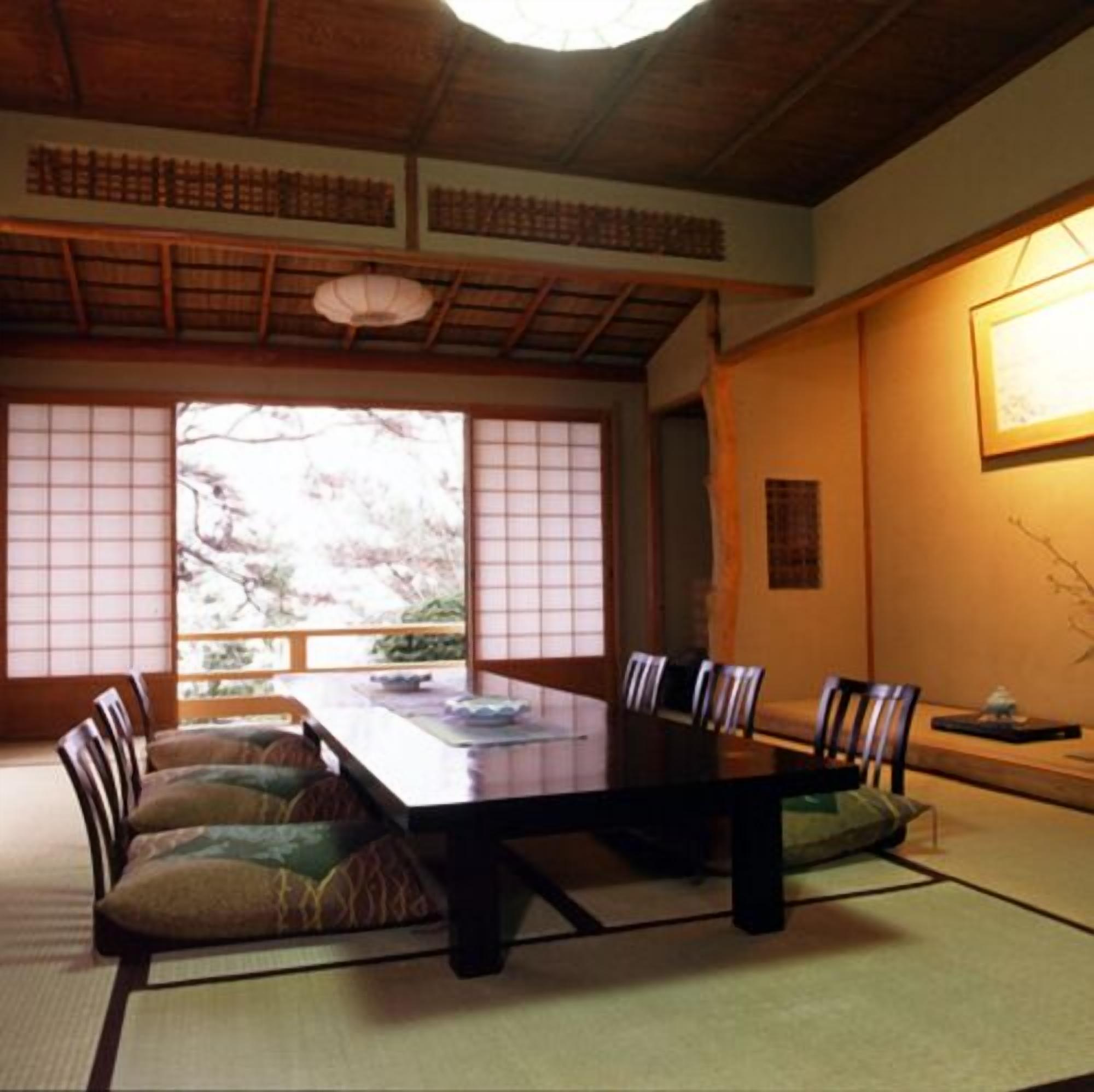 Una habitación japonesa tradicional con suelo de tatami, una mesa baja y puertas correderas shoji.