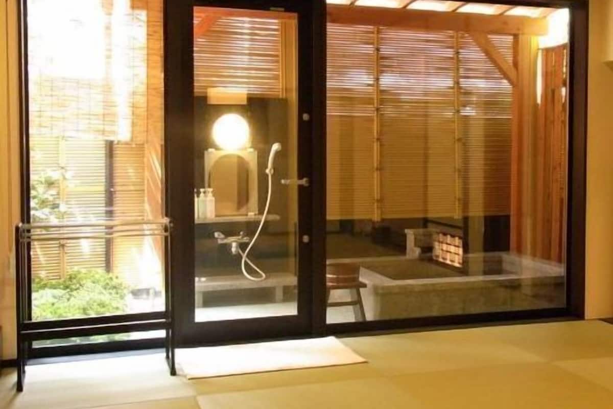 A modern bathroom with a glass partition, a toilet, a sink, and a shower area.