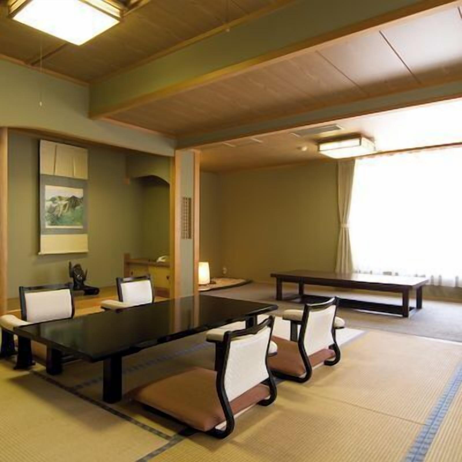 Un salón de conferencias con una larga mesa, sillas y un cuadro en la pared.
