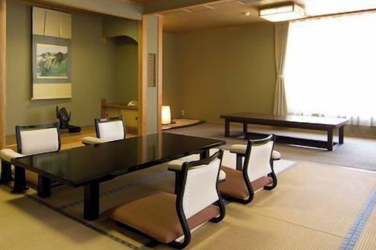 A conference room with a long table, chairs, and a painting on the wall.