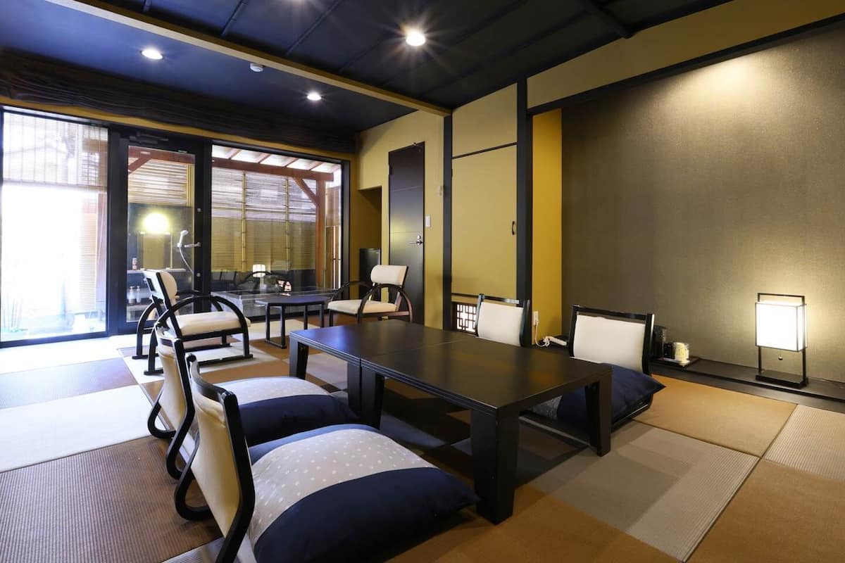 A conference room with a long table, chairs, tatami mats, and a large window.