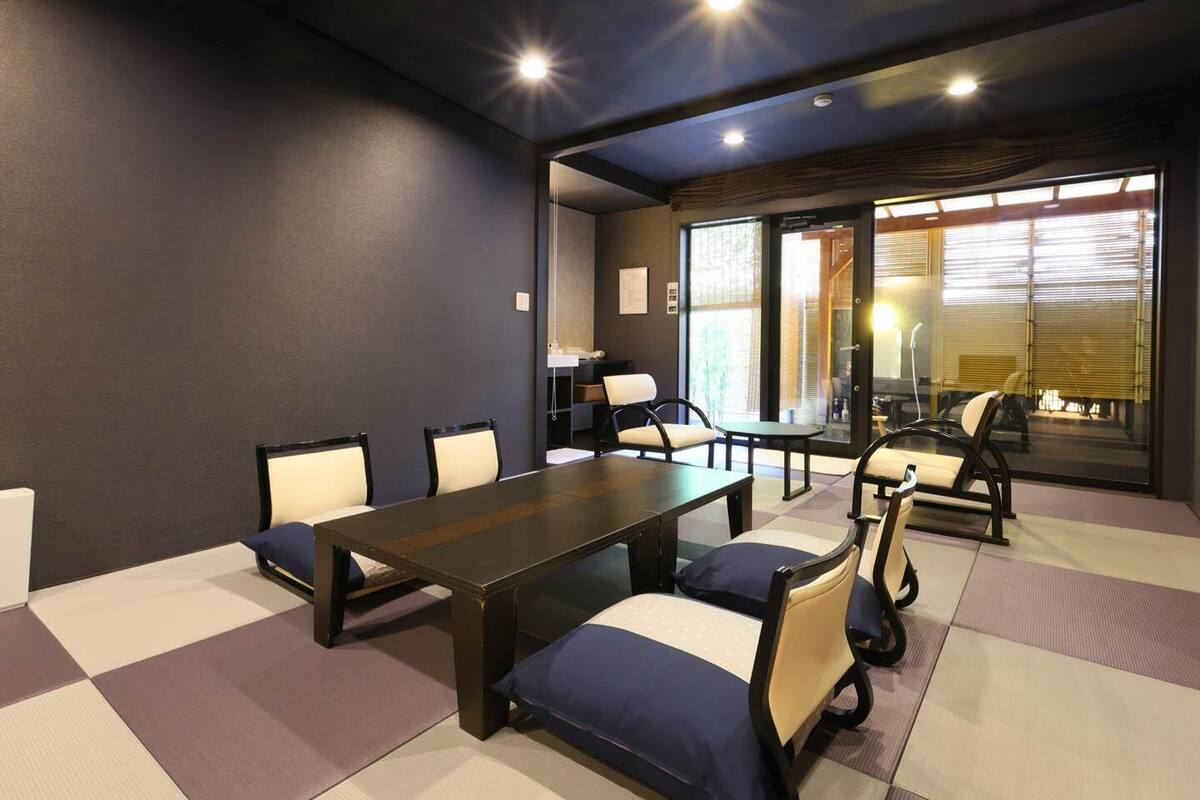A conference room with a long table, chairs, and a view through a glass door.