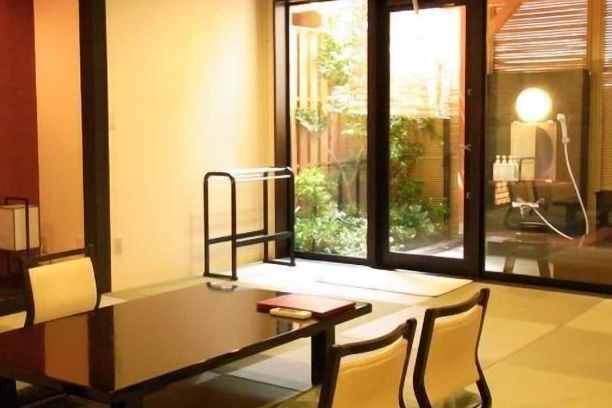 A modern room with a large sliding glass door, a dark wooden table, and two chairs.