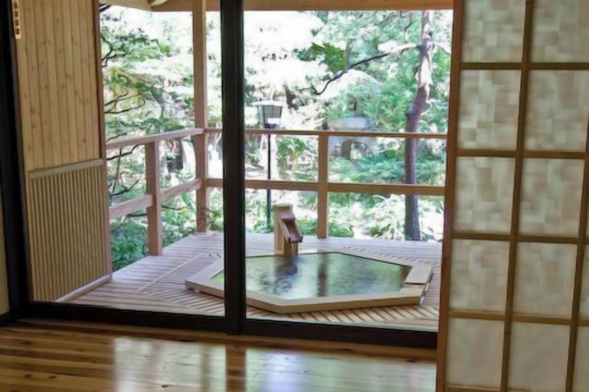 A room with a wooden floor, a tatami mat area, a table, and chairs.