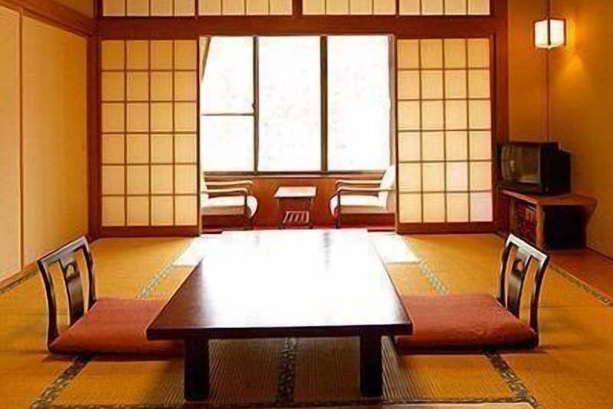 A traditional Japanese room with tatami flooring, a low table, and sliding doors.