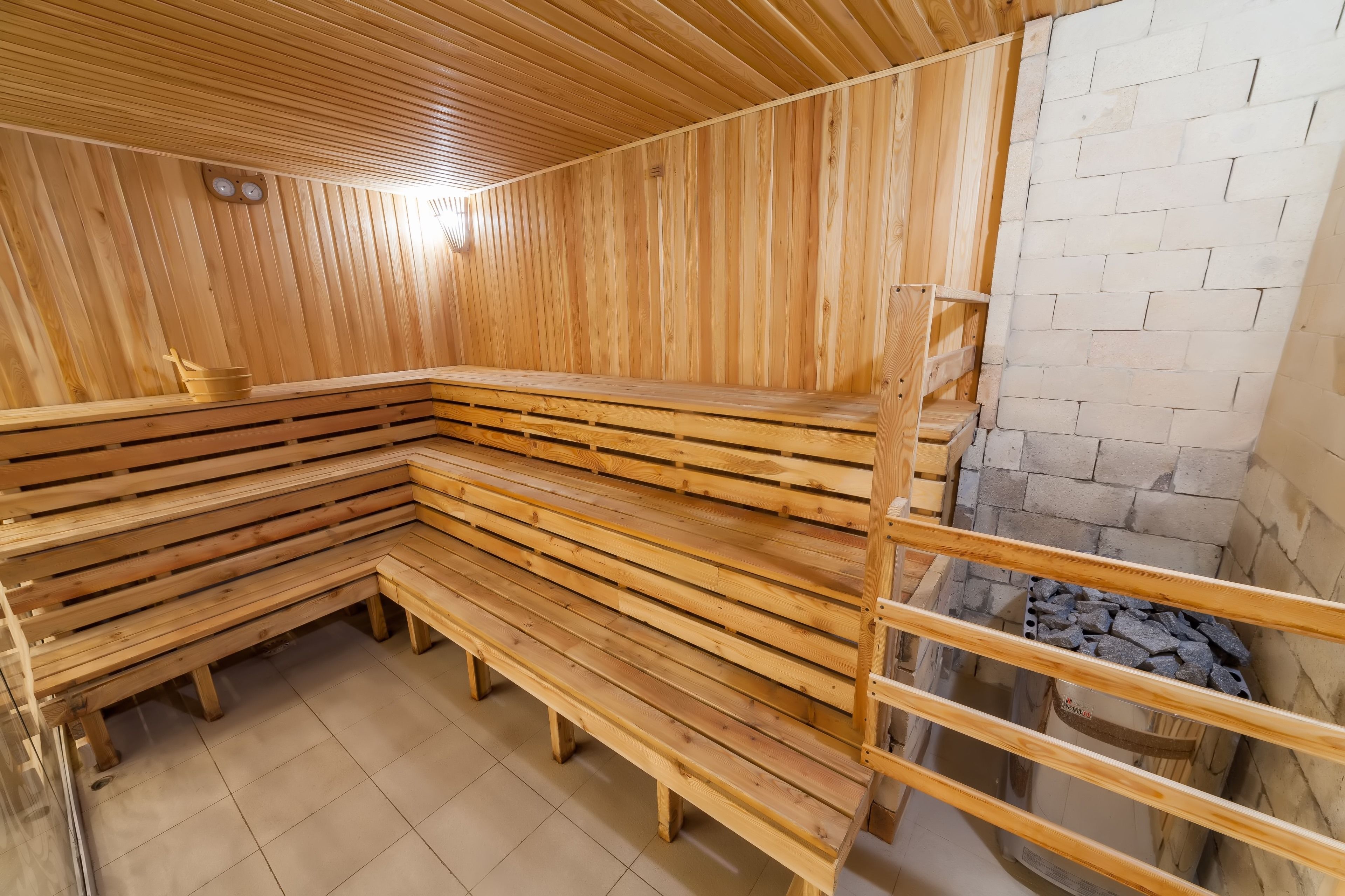 En sauna med træbænke og en stenvæg.