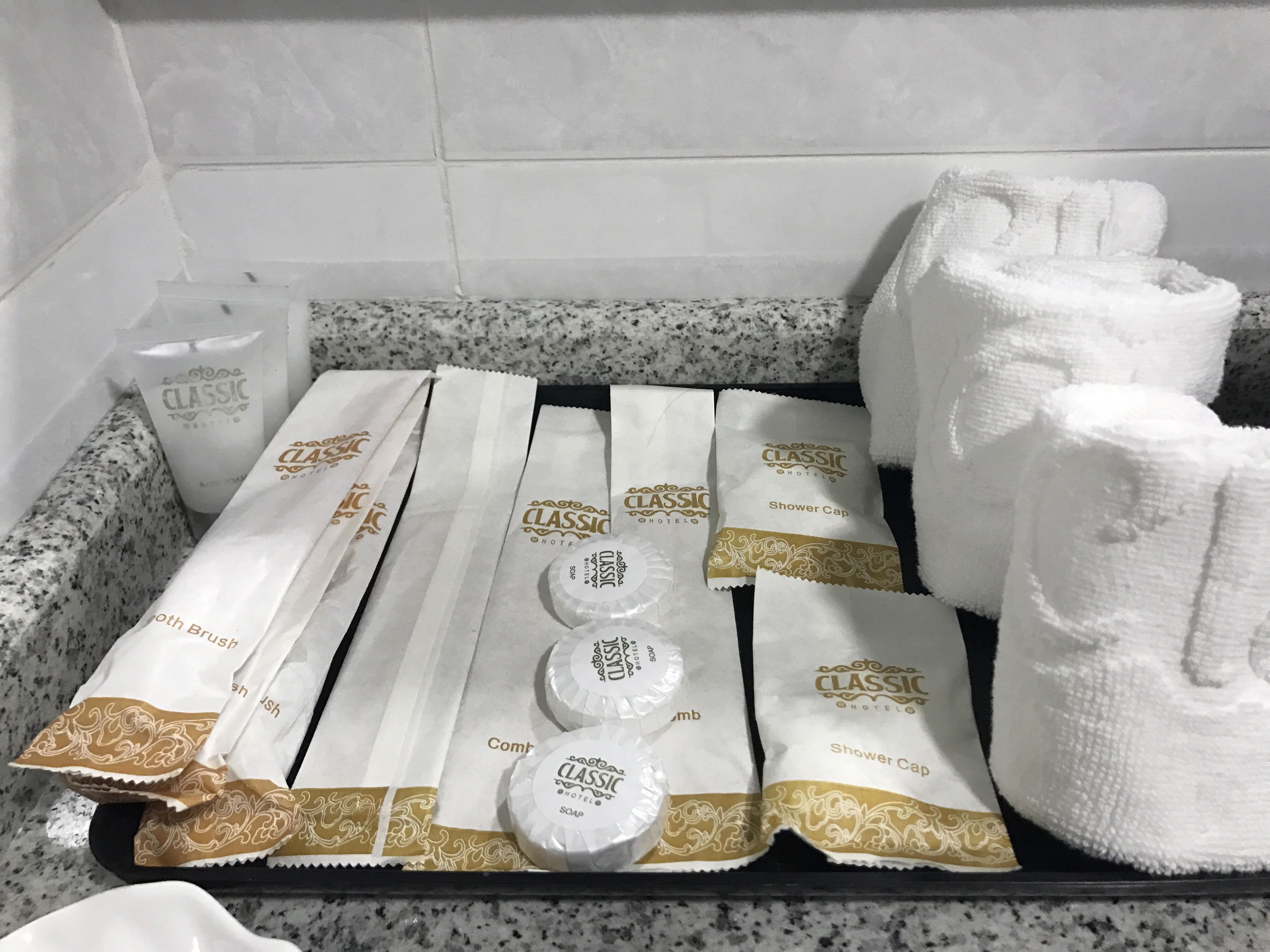 A tray with toiletries including a shower cap, soap, and a bottle of shampoo.