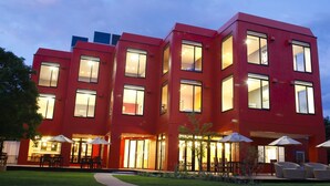 A modern red building with multiple windows and outdoor seating areas. - Lake Side Hotel & Restaurant Little White Flower (Kyotango)