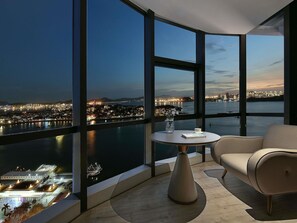 Ein modernes Zimmer mit einem großen Panoramafenster, einem runden Tisch und einer Couch.