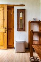 Una habitación de madera con un armario grande, un espejo, un banco y una mesita.