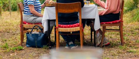Un grupo de personas cenando al aire libre en una mesa, con vistas a la montaña.