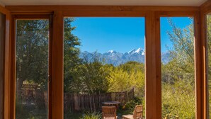 A room with a large sliding glass door leading to an outdoor patio with a view of mountains.