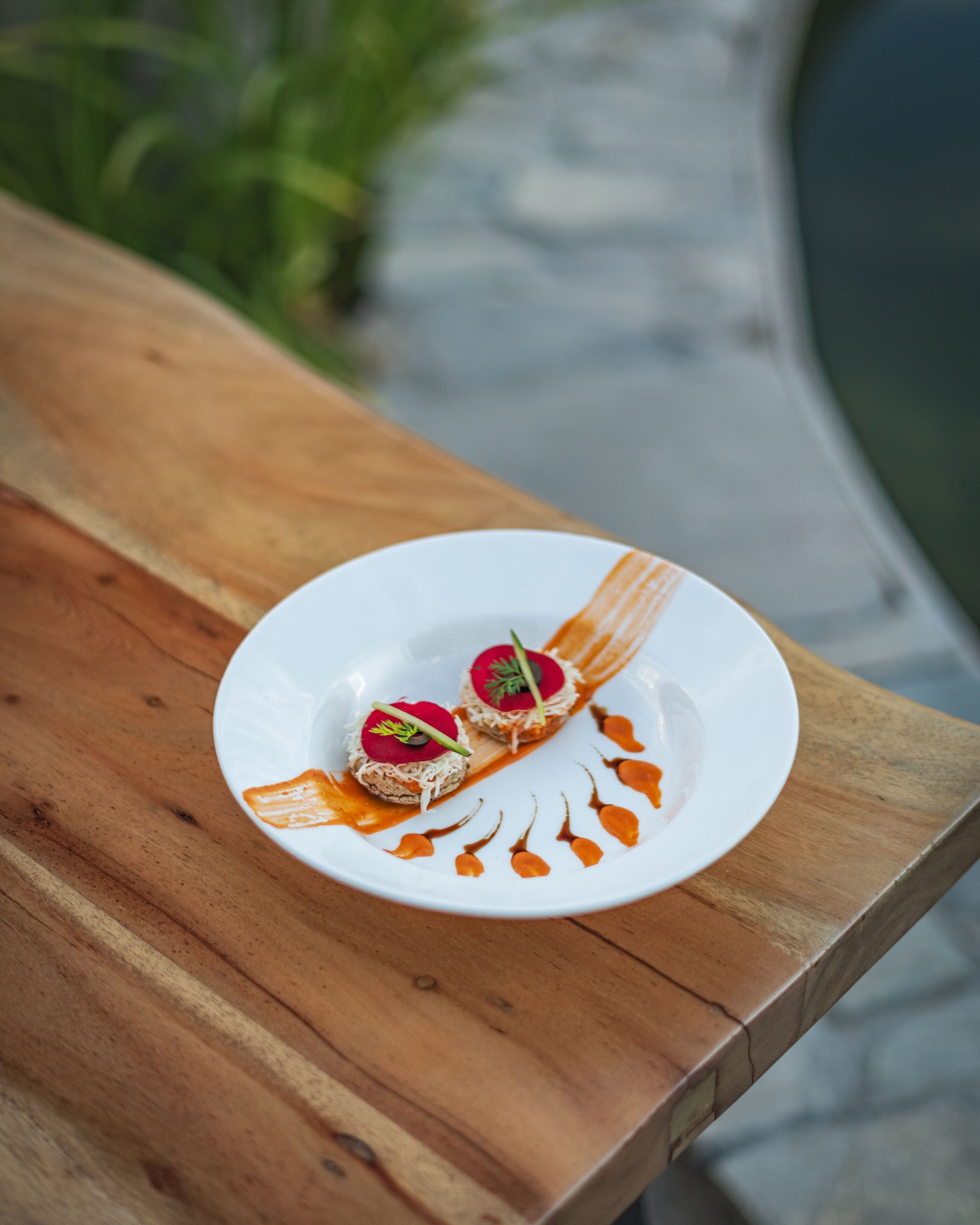 A white plate with two food items on a wooden table.