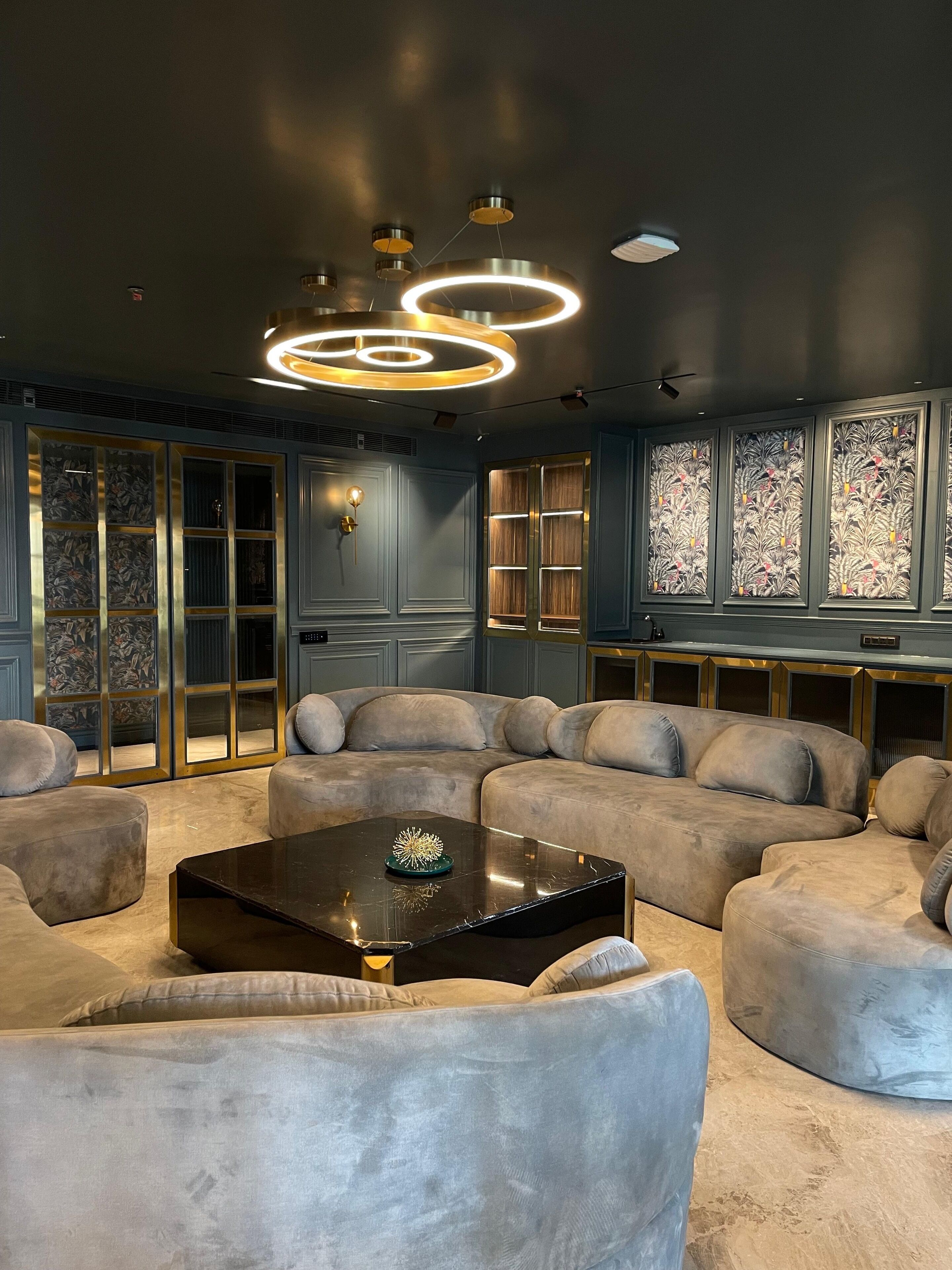 Un soggiorno moderno con un divano componibile, un tavolino da caffè e un lampadario decorativo.