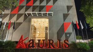 A building with a geometric facade and a prominent illuminated sign reading "Kauris". - Aauris (Kolkata)