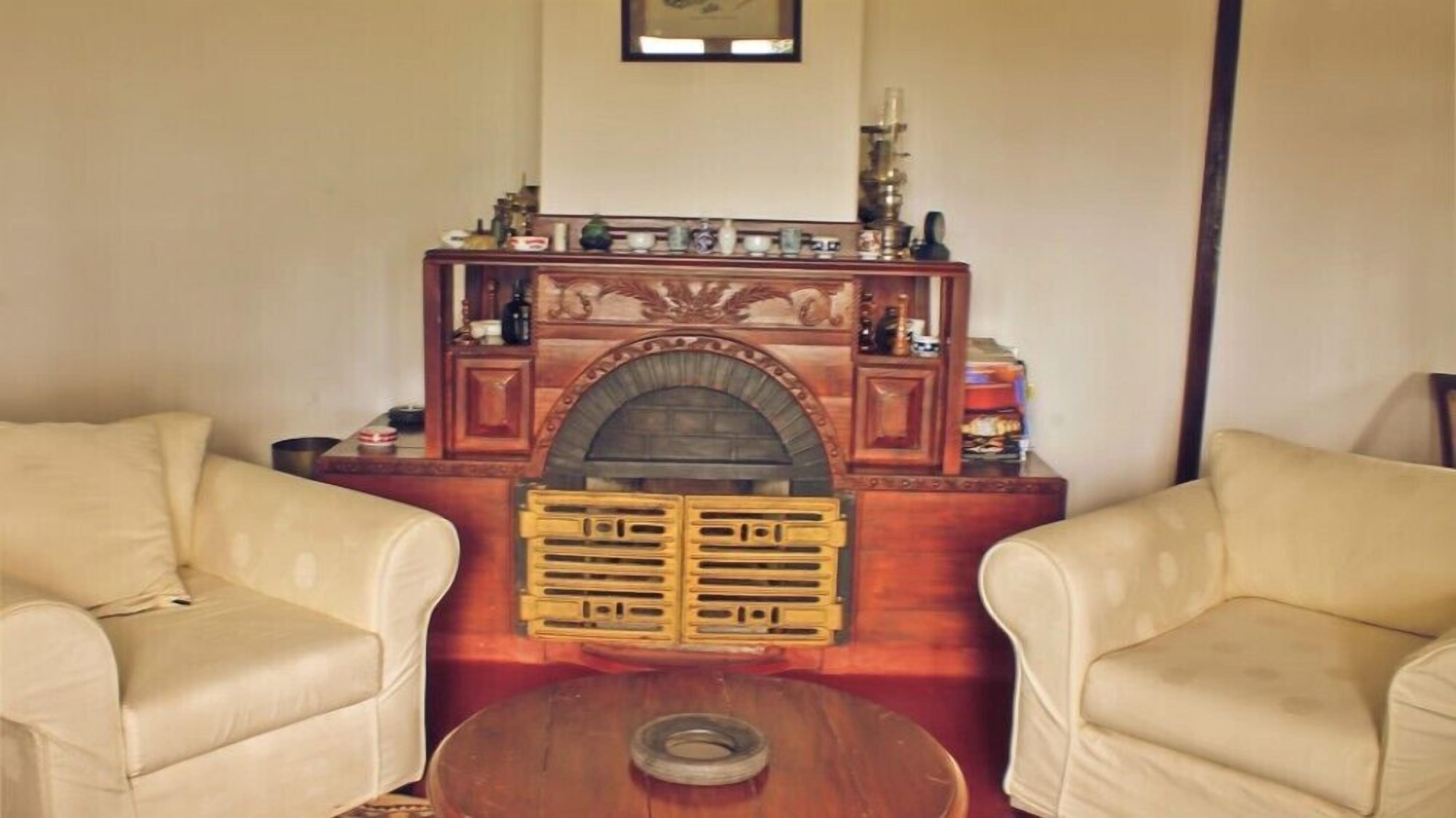 Una sala de estar con chimenea, dos sillones de cuero y una mesita de centro.