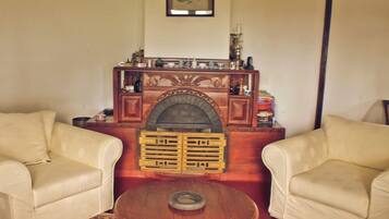 Una sala de estar con chimenea, dos sillones de cuero y una mesita de centro.