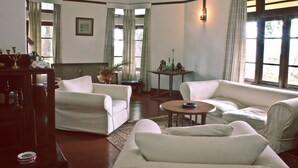 A room with two white sofas, a small round table, and a decorative vase.