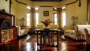 A traditional living room with a fireplace, two sofas, a coffee table, and a rug.
