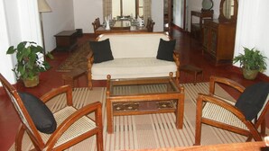 Una sala de estar con un sofá, sillas, una mesa de centro y una mesa de comedor lista para cuatro personas.
