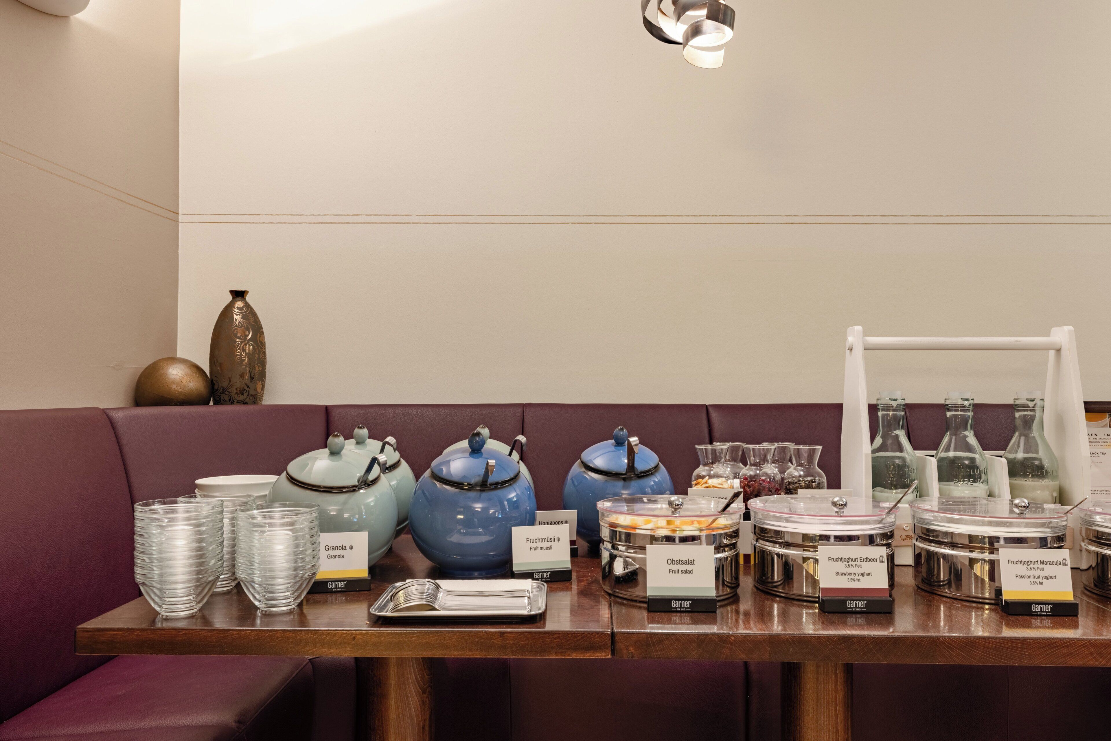 A breakfast buffet setup with various food items and containers.