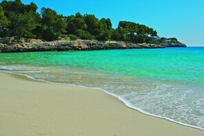 Ubicación cercana a la playa, arena blanca y sombrillas