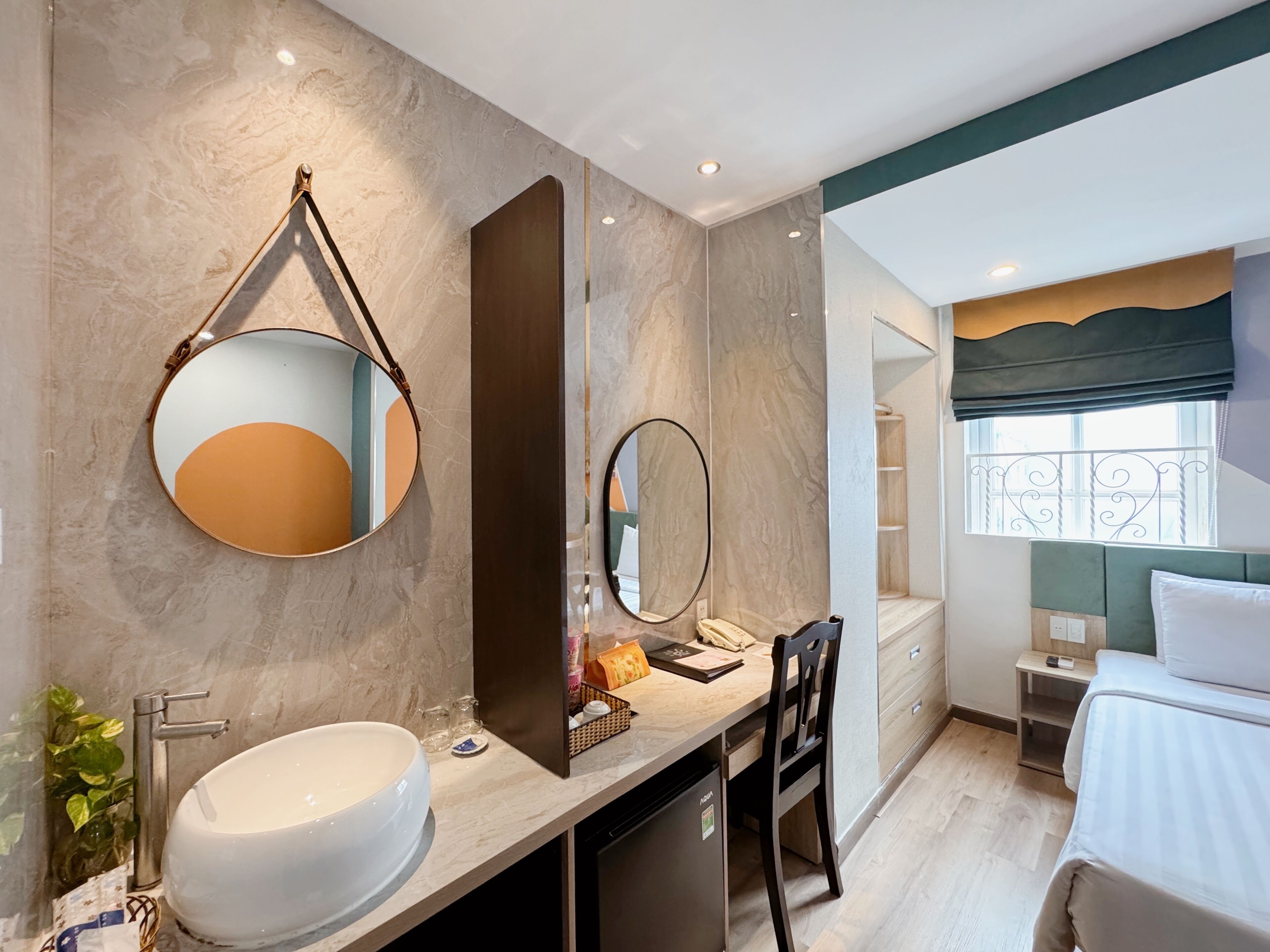 Un baño moderno con un lavamanos grande, dos espejos, un inodoro y zona de ducha.