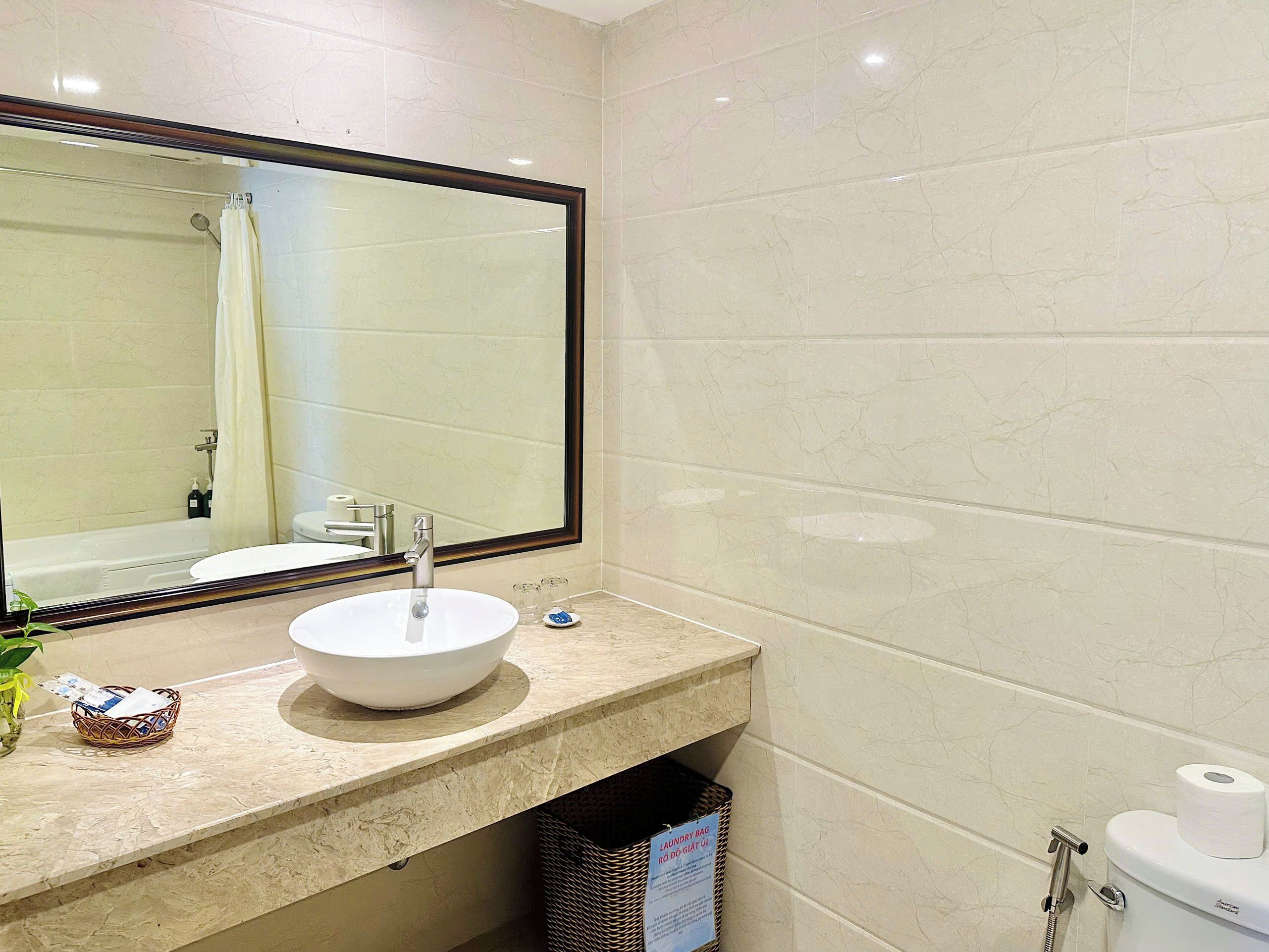 A bathroom with a sink, mirror, toilet, and shower.