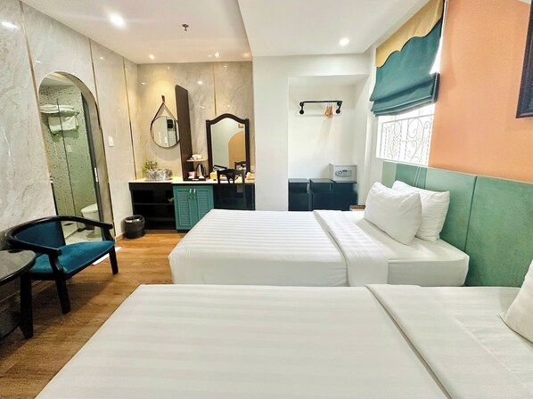 A hotel room with two beds, a desk, a chair, a mirror, and a window with curtains. - Sunrise Central Hotel (Ho Chi Minh City)