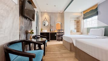A hotel room with a bed, a desk, a chair, a mirror, and a television.