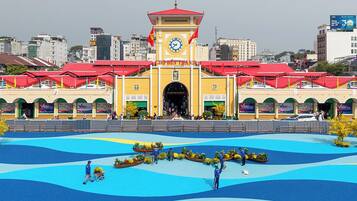 A building with a clock tower, a central entrance, and a surrounding plaza with a water feature.