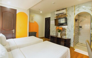 A hotel room with two beds, a TV, an air conditioning unit, a shower, and a decorative wall.