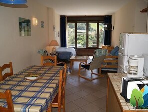 Una habitación acogedora con cama, escritorio, silla y cafetera.