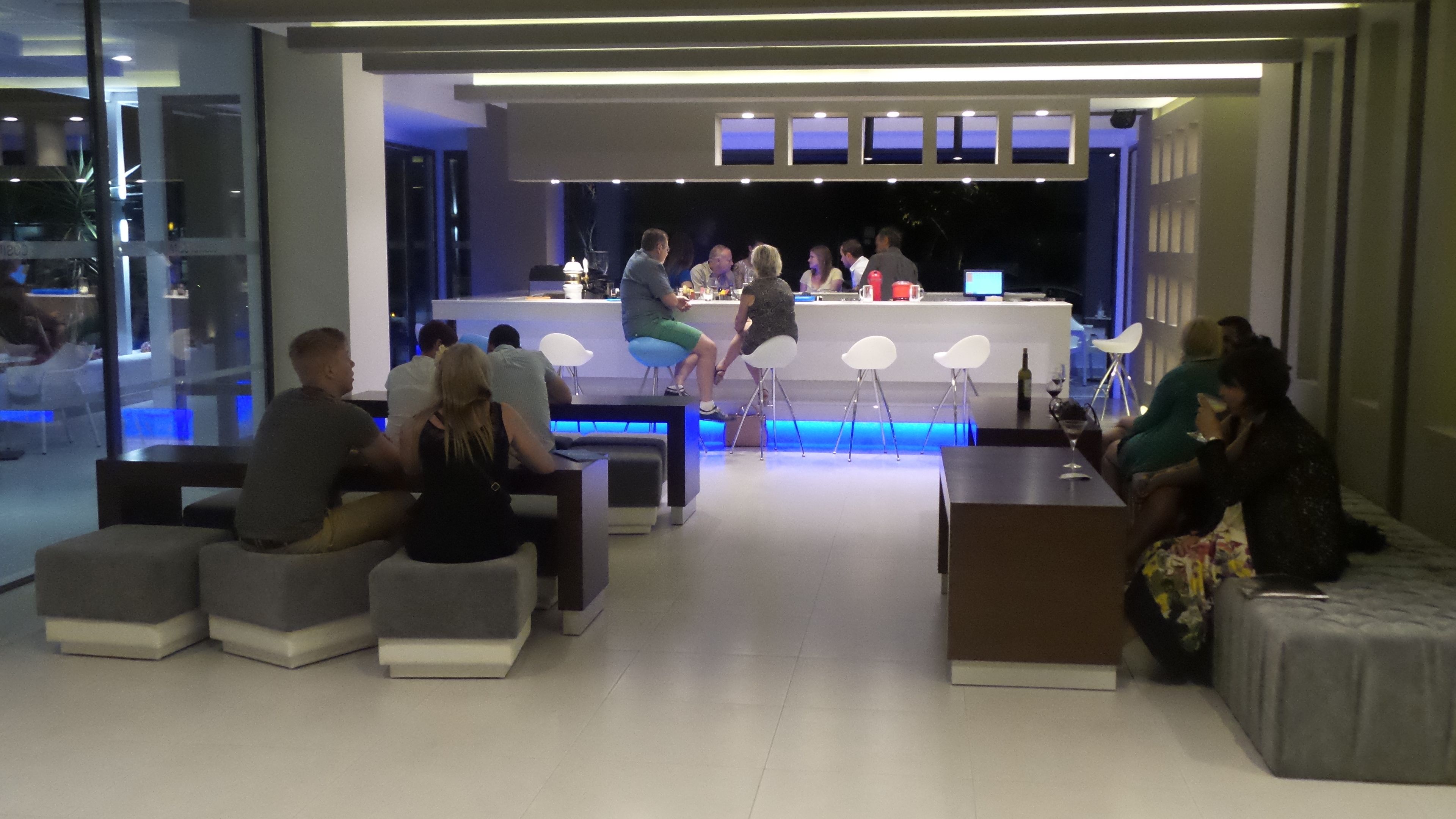 A modern bar area with seating and a counter.