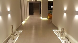 A hallway with a tiled floor, white walls, and a staircase at the end. - Cosmopolitan Kos Hotel (Kos)