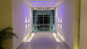 A modern hotel entrance with glass doors, a central pathway, and ambient lighting. - Cosmopolitan Kos Hotel (Kos)