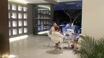 Un comedor interior con muebles modernos y ventanas grandes.
