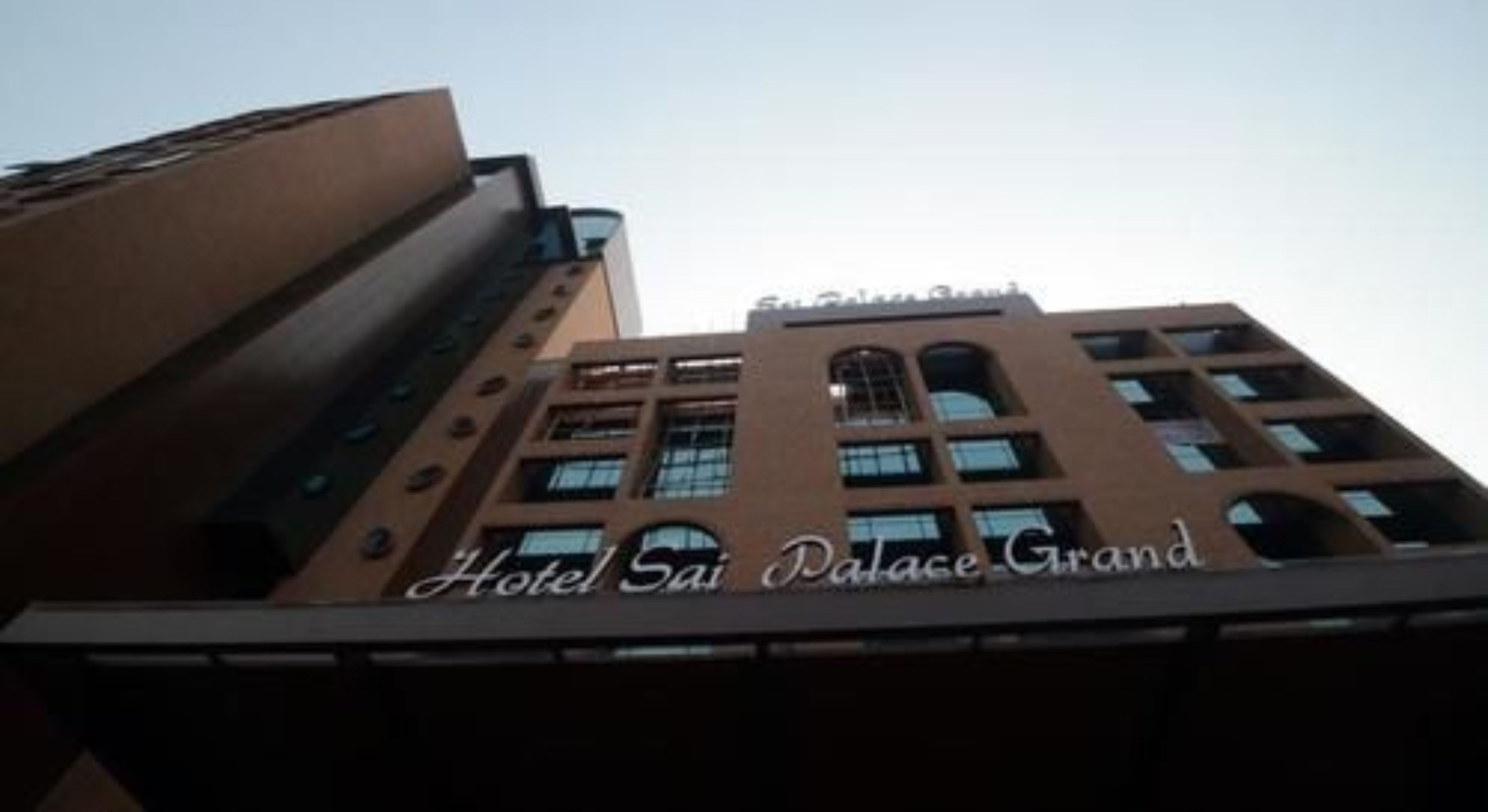 A building with the sign "Hotel Sai Palace Grand" indicating it is a hotel.