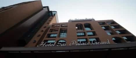 A building with the sign "Hotel Sai Palace Grand" indicating it is a hotel.