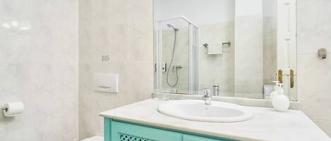 Ein Badezimmer mit Toilette, Waschbecken, Dusche und Spiegel.