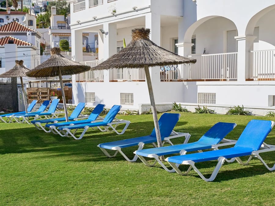 Una piscina al aire libre, sillones reclinables de piscina