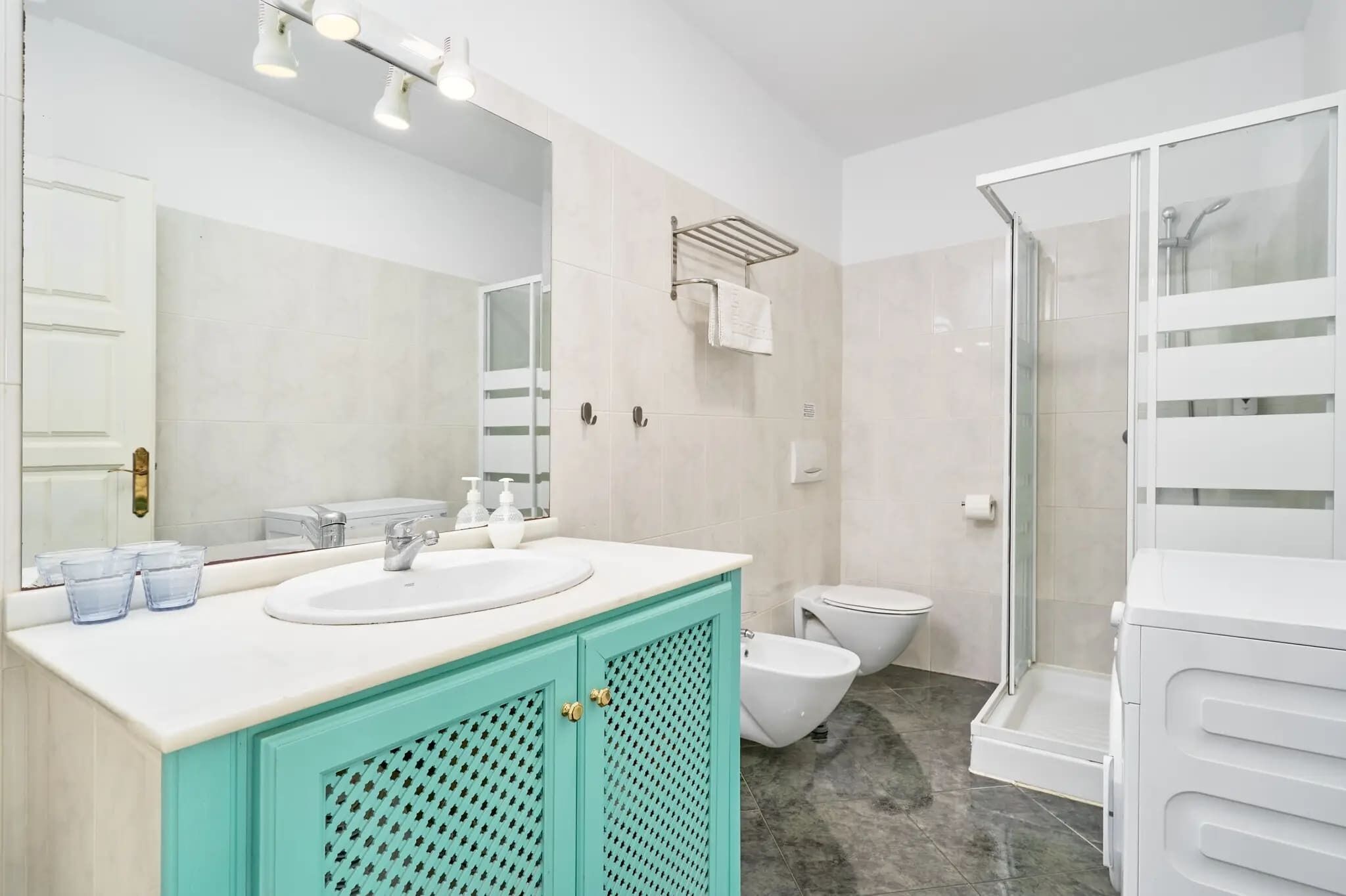 A modern bathroom with a sink, mirror, and shower.