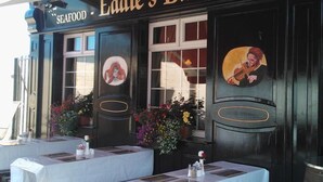Bar Eddie - Bistro con terraza y letrero de mariscos.
