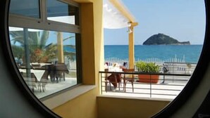 Un balcón con vista al mar y una pequeña isla.